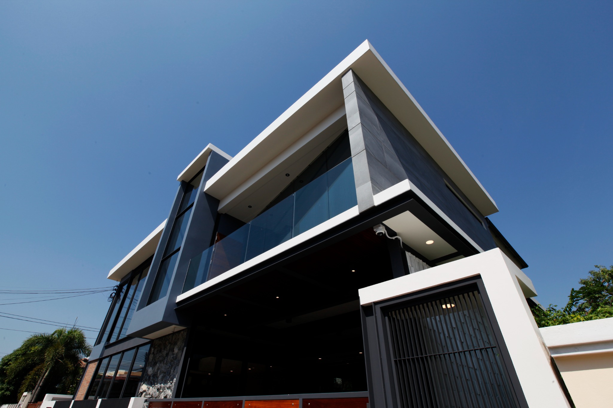 Front exterior of KB Home Lumlukka with white structural frames and a dark metal facade