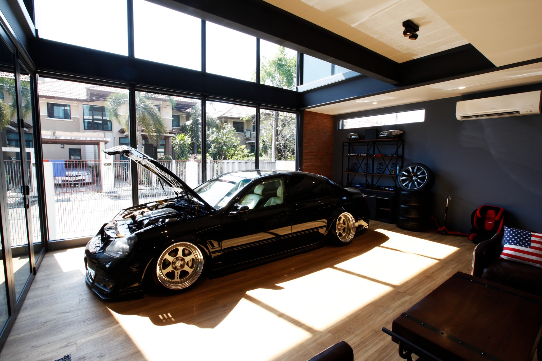 Car display garage with full-height glazing and a timber ceiling