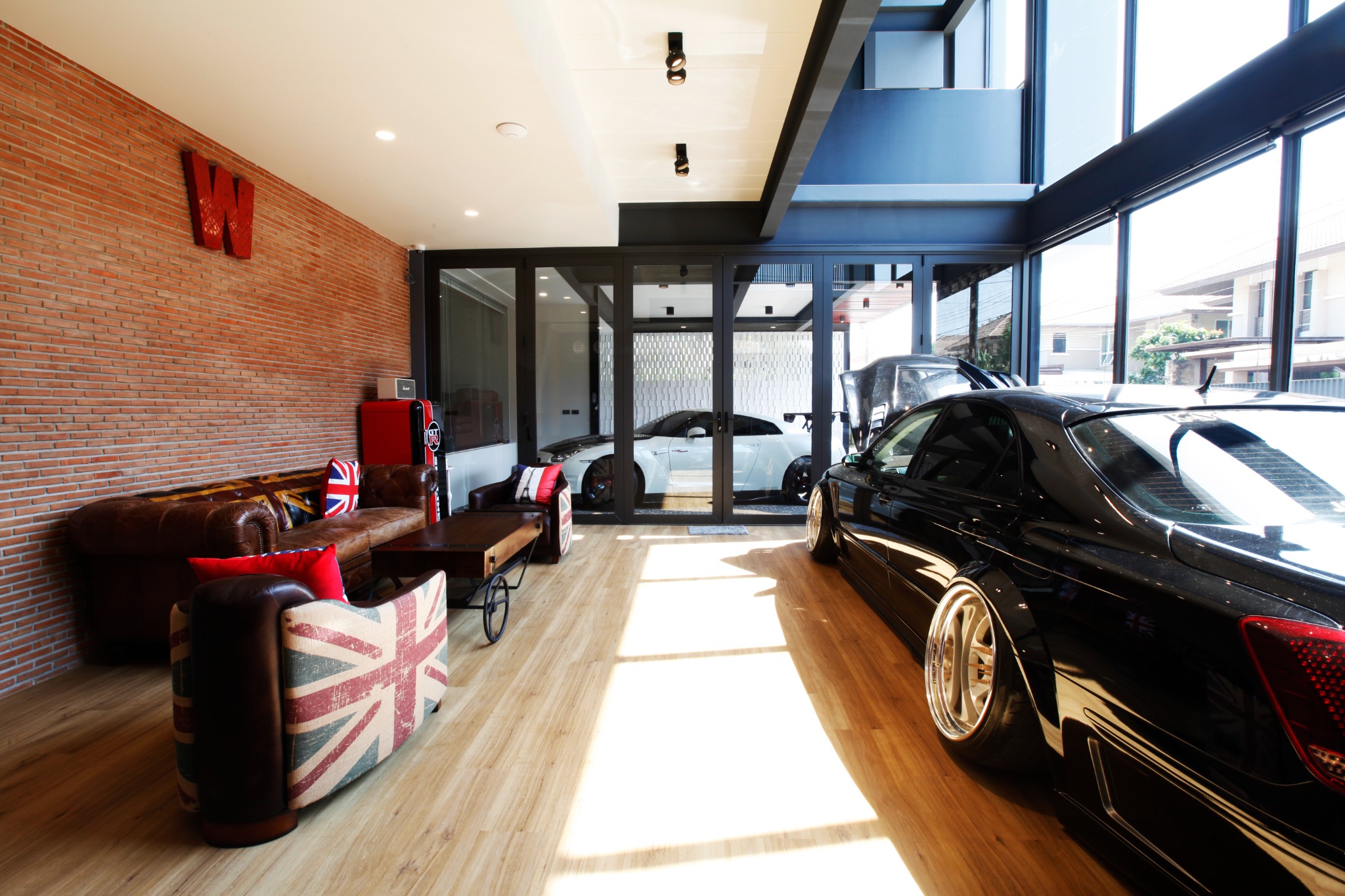 Garage lounge with a brick wall, cars and timber flooring