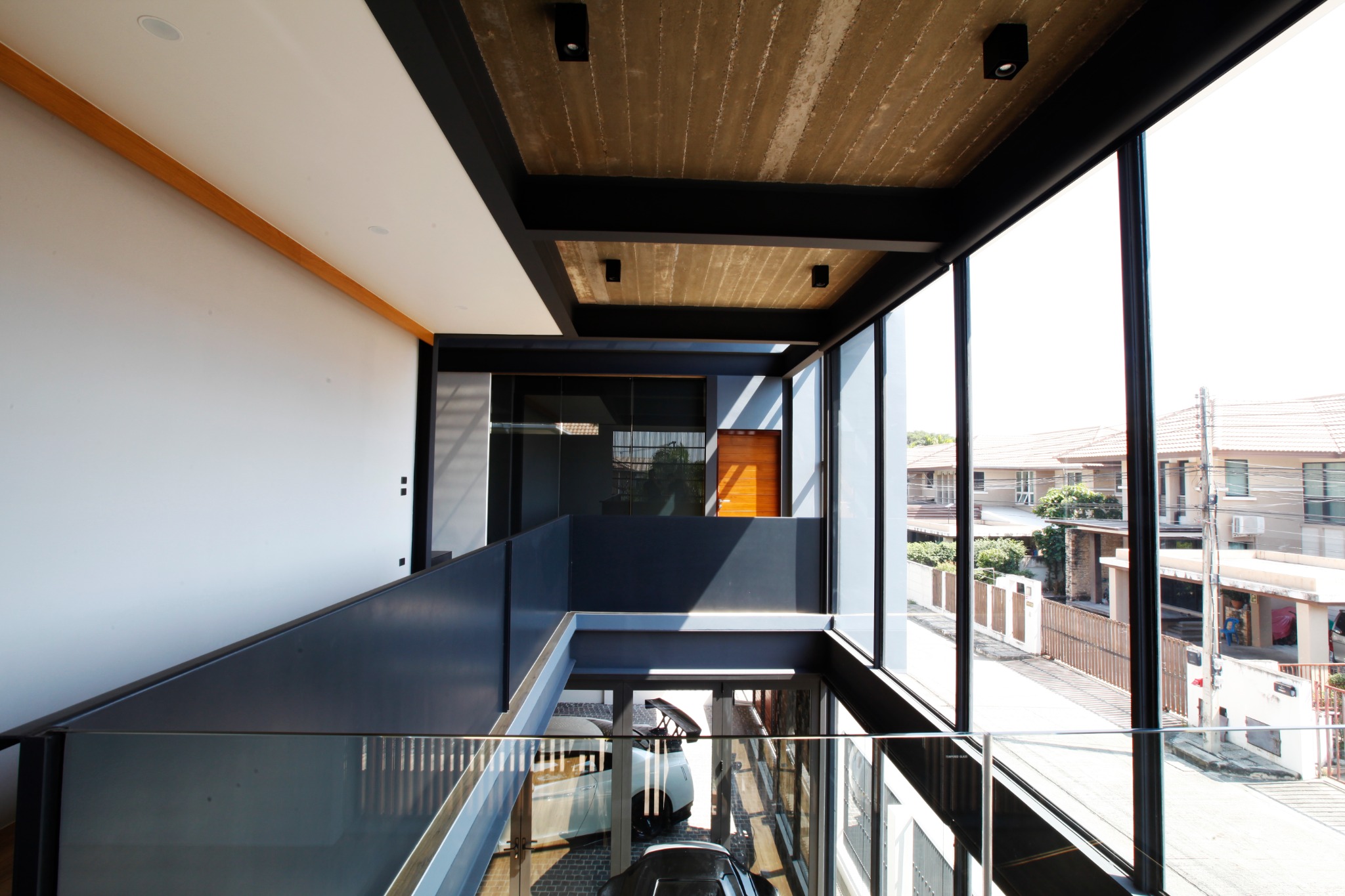 Upper-floor bridge and black metal railing beside the glazed facade