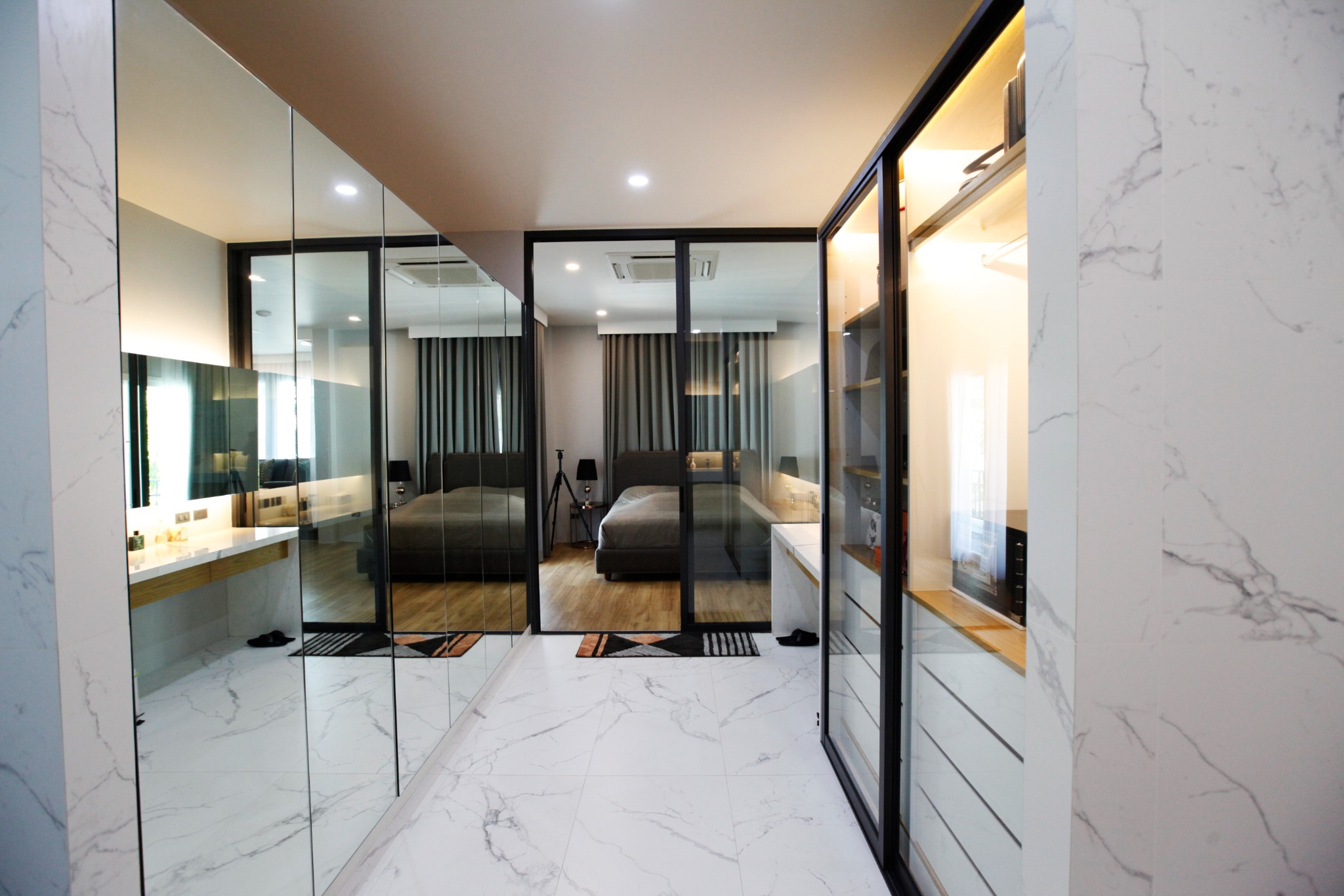 Bathroom and dressing area with marble finishes and black-framed glass partitions