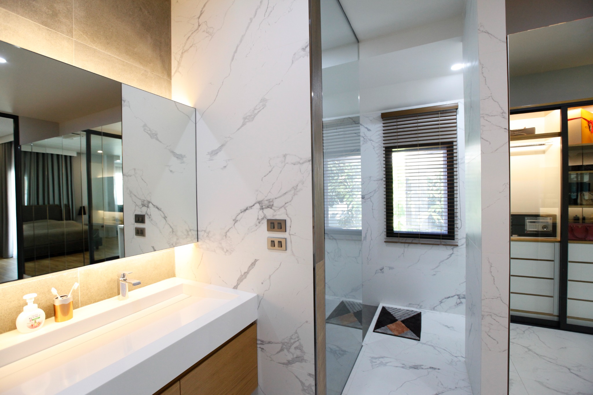 Marble vanity and shower area with black-framed glazing