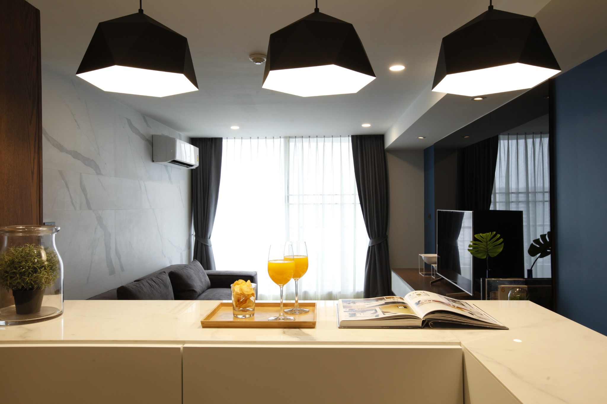 Kitchen island looking toward the living room with black pendant lights