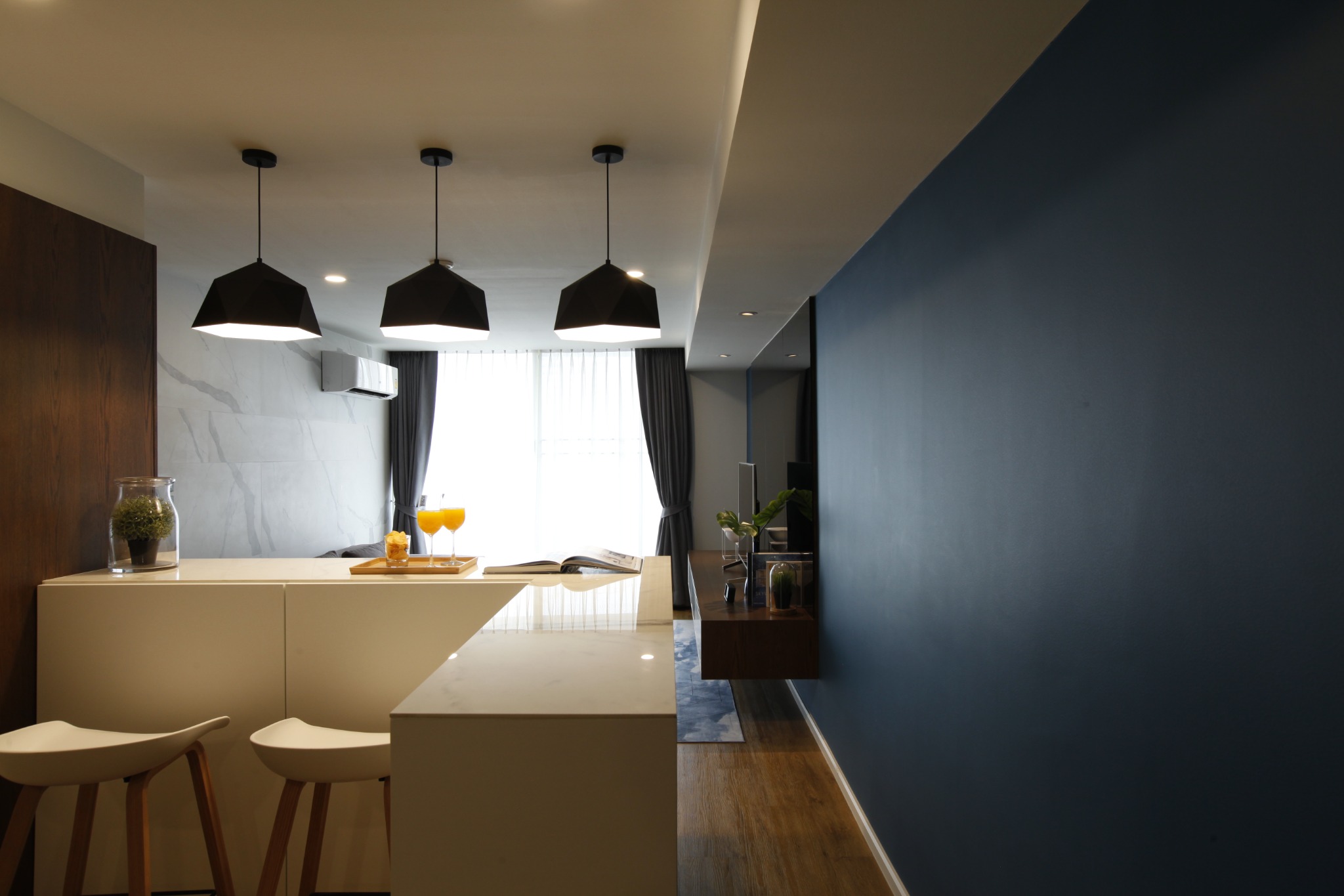 White kitchen island and deep blue feature wall in the open-plan interior