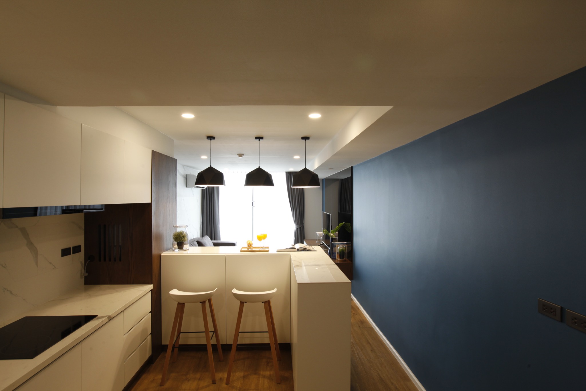 Galley kitchen with white cabinetry, marble backsplash and breakfast bar