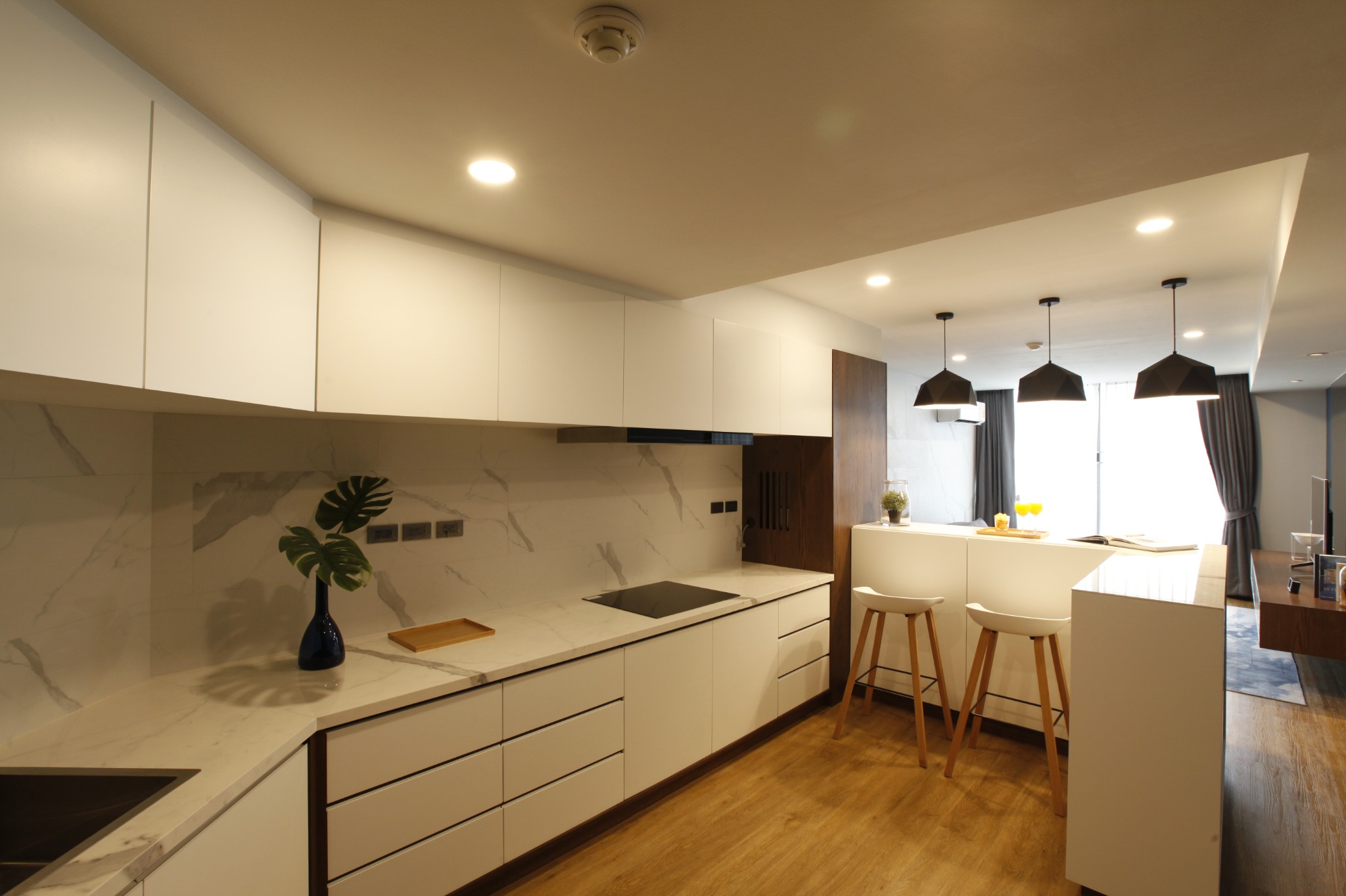 Compact kitchen with marble worktop, concealed storage and timber flooring