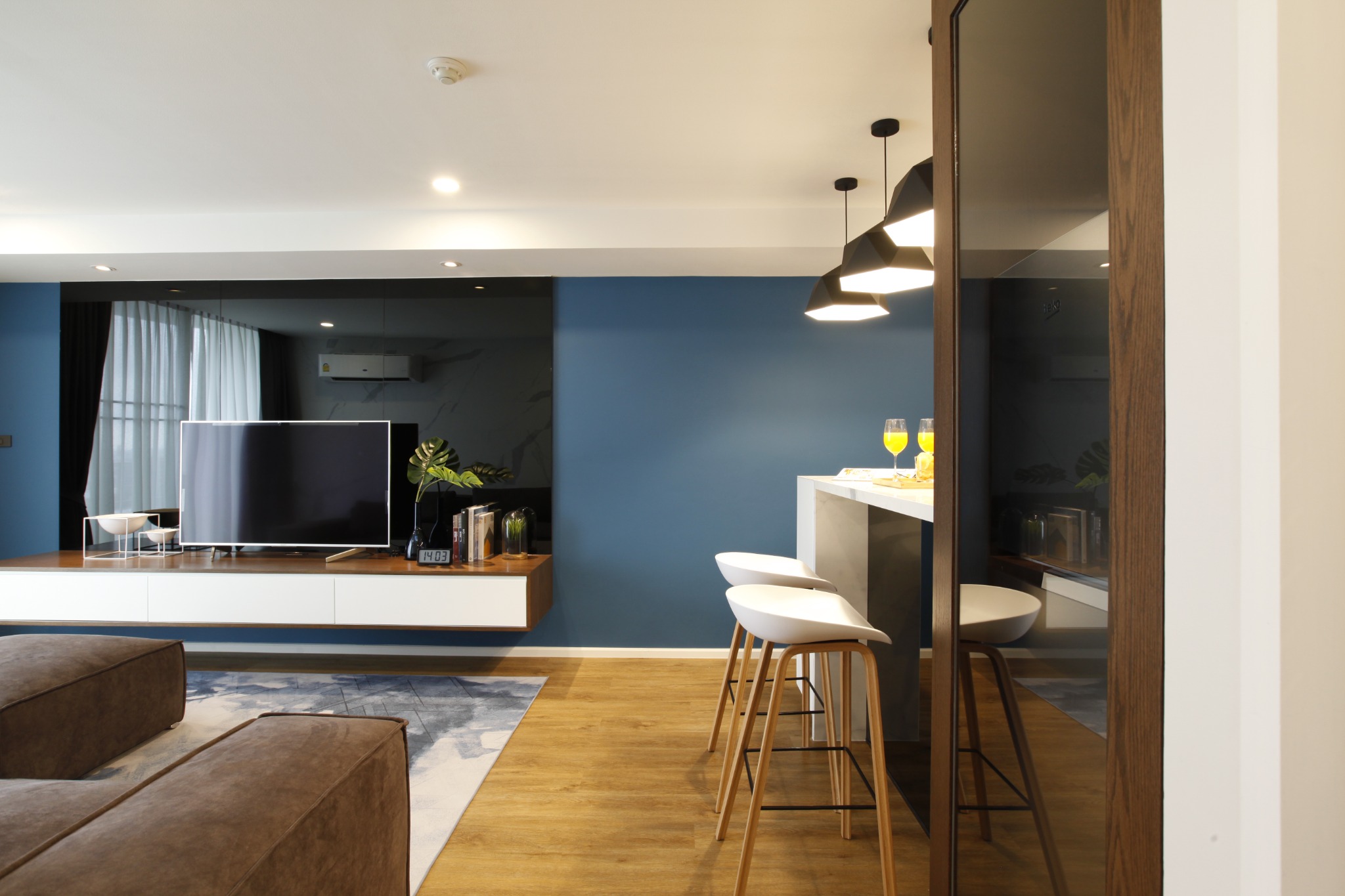 Living room and kitchen viewed from the entrance with coordinated blue and timber finishes